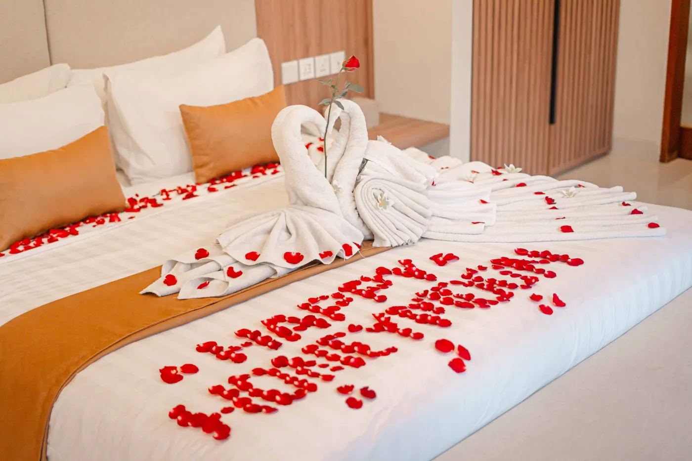 Luxurious Bali pool villa with private plunge pool, red bean bag chairs, and open doors to a rose petal-adorned bedroom. - Bali Villas