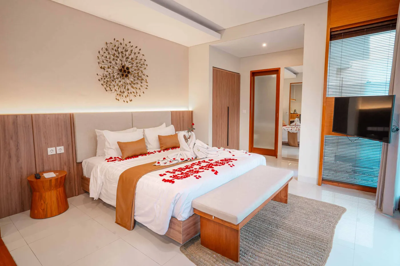 Luxurious Bali pool villa with private plunge pool, red bean bag chairs, and open doors to a rose petal-adorned bedroom. - Bali Villas