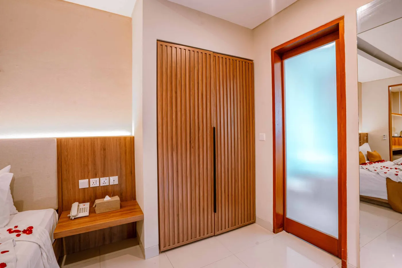 Luxurious Bali pool villa with private plunge pool, red bean bag chairs, and open doors to a rose petal-adorned bedroom. - Bali Villas