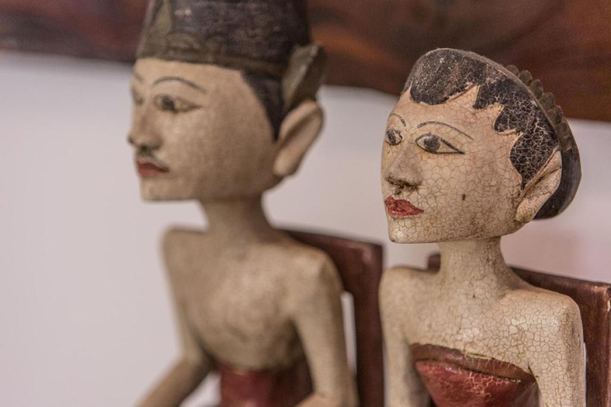 Modern wooden bathroom vanity with rattan accents, double sink, mirror, towels, and tropical decor. - Bali Villas