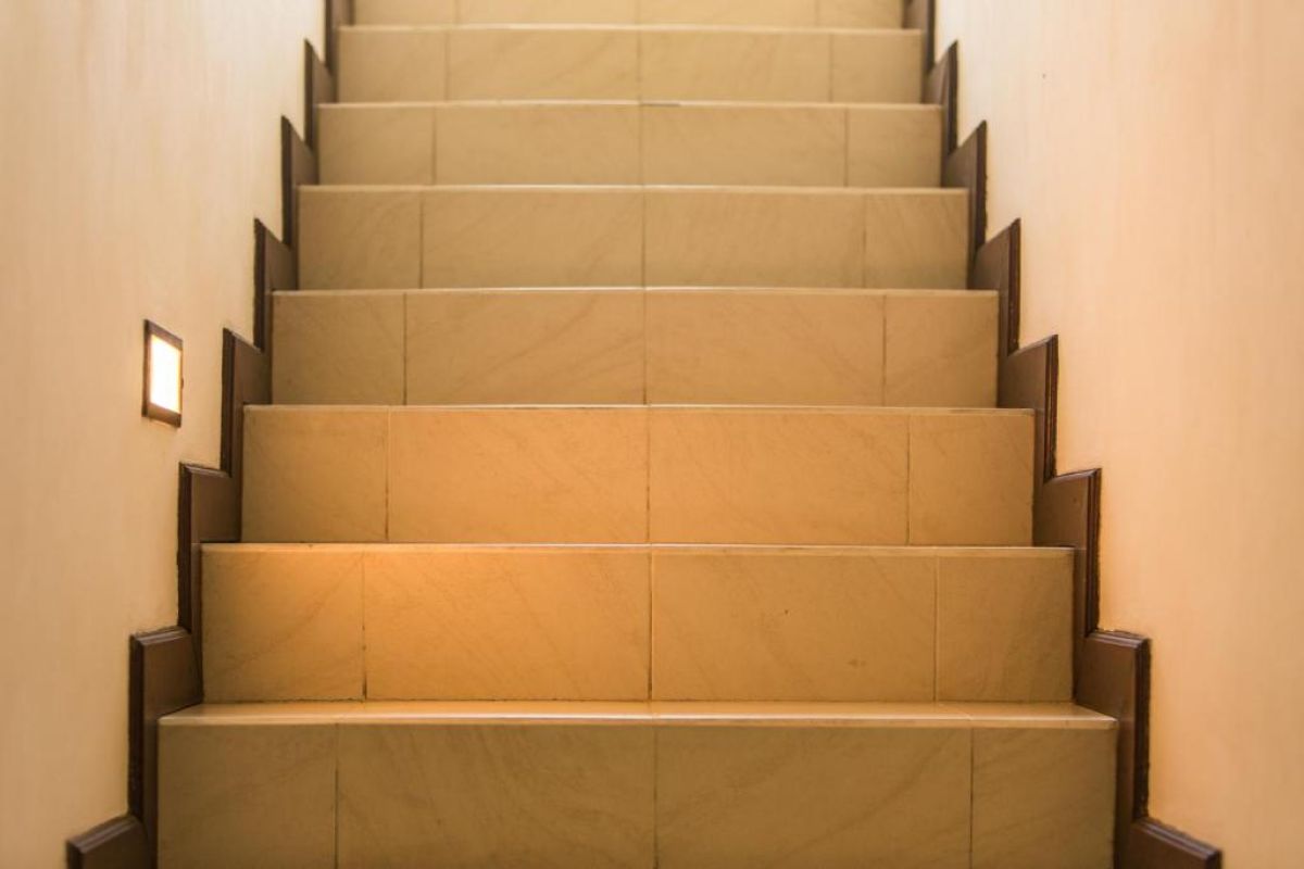 Modern wooden bathroom vanity with rattan accents, double sink, mirror, towels, and tropical decor. - Bali Villas