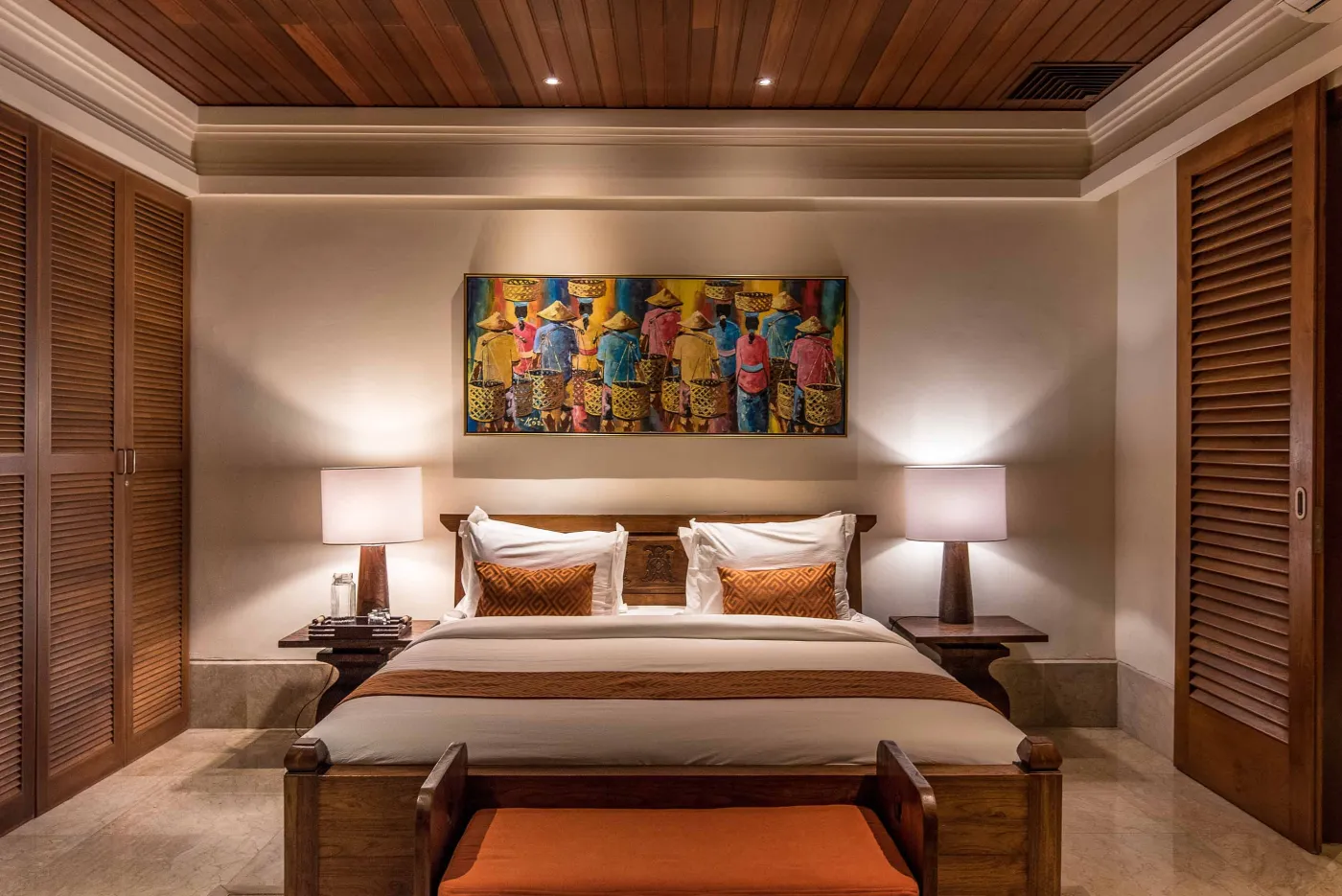 Luxurious tropical bathroom featuring a freestanding white bathtub, wooden vanity with double sinks, large mirror, and open door to lush greenery. - Bali Villas