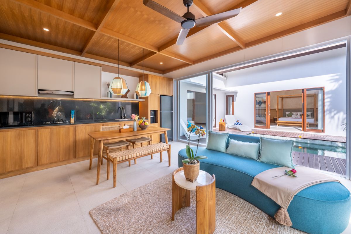 Modern luxury bathroom with soaking tub filled with water and lotus flowers, glass shower enclosure, tropical plants, and natural stone vanity. - Bali Villas
