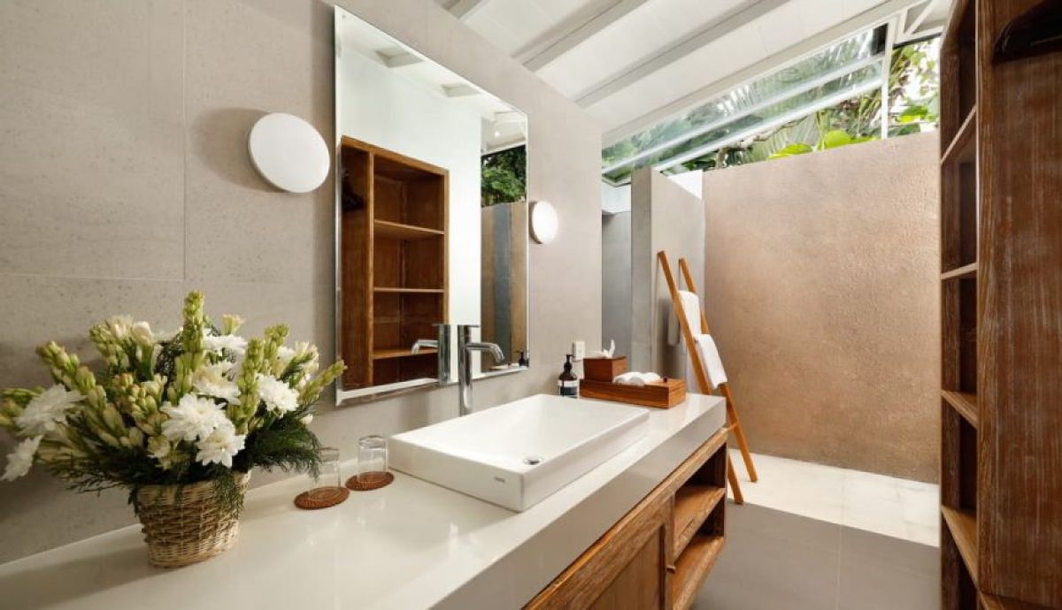 Modern Bali-style villa with infinity pool, lush tropical garden, white architecture, and sunny courtyard. - Bali Villas