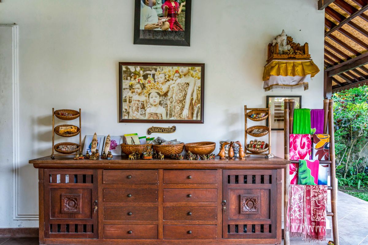 Spacious open-air Balinese pavilion restaurant with thatched roof, wooden tables set for dining, and lush tropical greenery. - Bali Villas