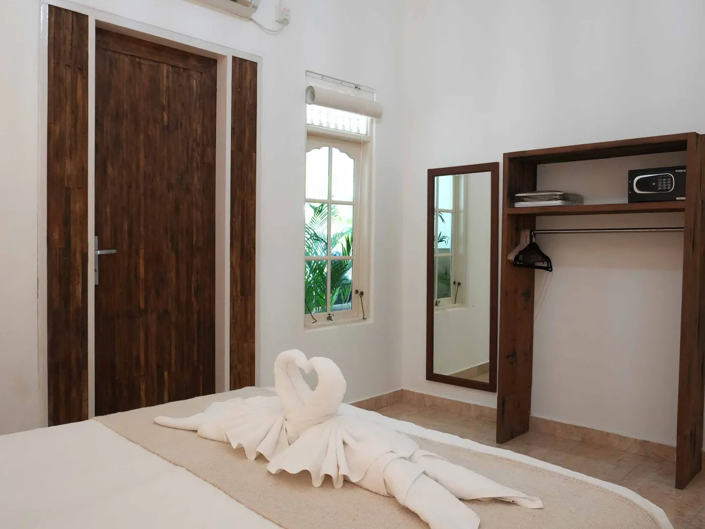 Modern bathroom with glass shower enclosure, rain showerhead, and wooden vanity sink. - Bali Villas