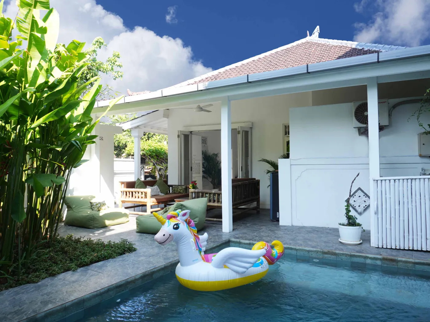 Modern bathroom with glass shower enclosure, rain showerhead, and wooden vanity sink. - Bali Villas