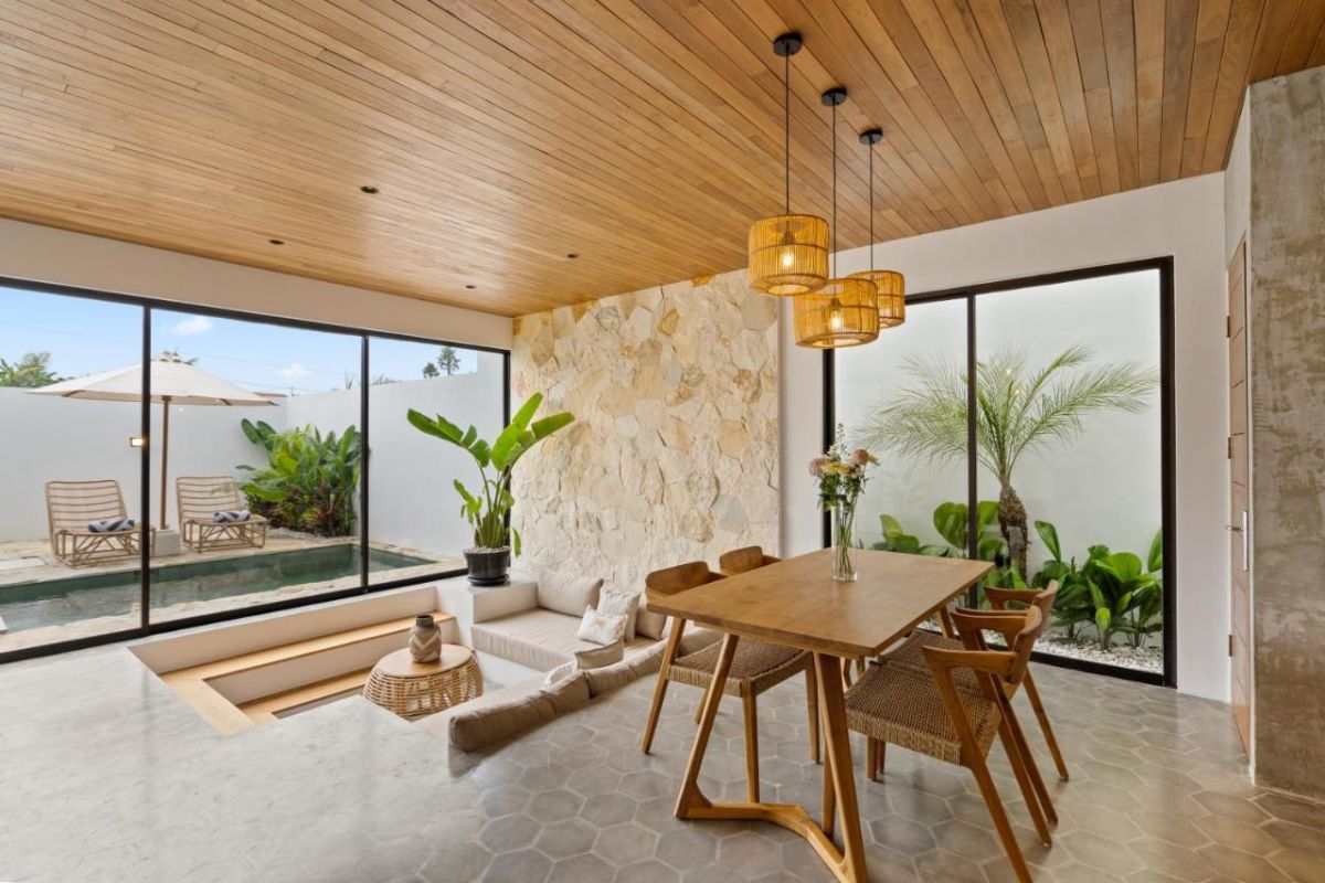 Serene modern bedroom with wooden bed, desk, and large windows overlooking lush green rice fields. - Bali Villas