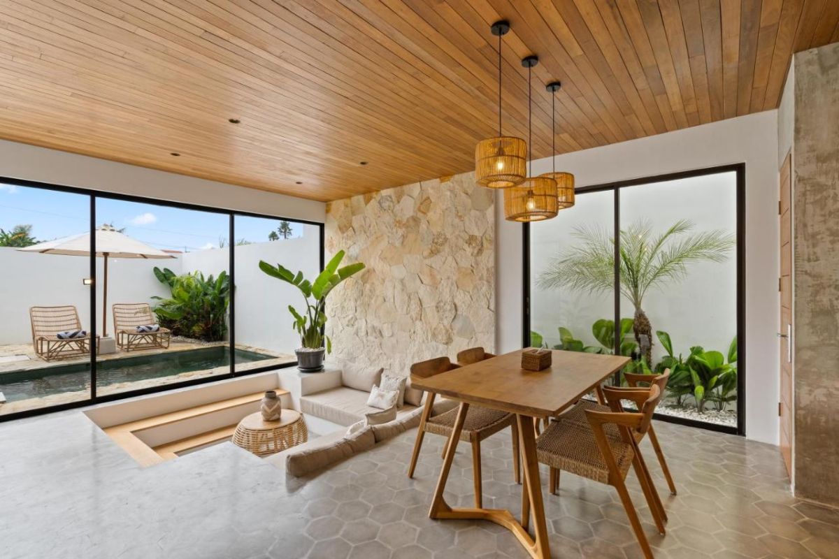 Serene modern bedroom with wooden bed, desk, and large windows overlooking lush green rice fields. - Bali Villas