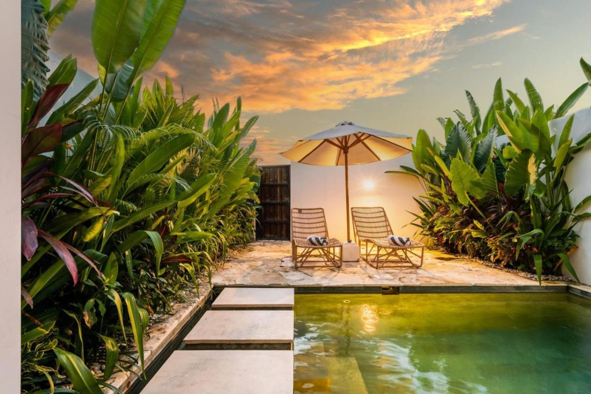 Serene modern bedroom with wooden bed, desk, and large windows overlooking lush green rice fields. - Bali Villas