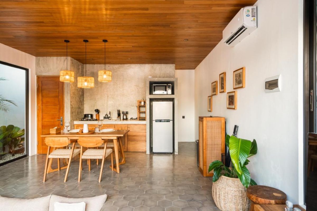 Serene modern bedroom with wooden bed, desk, and large windows overlooking lush green rice fields. - Bali Villas