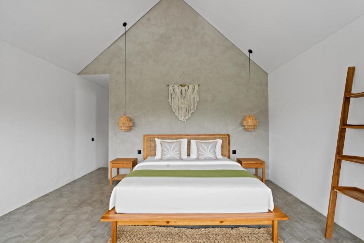 Serene modern bedroom with wooden bed, desk, and large windows overlooking lush green rice fields. - Bali Villas