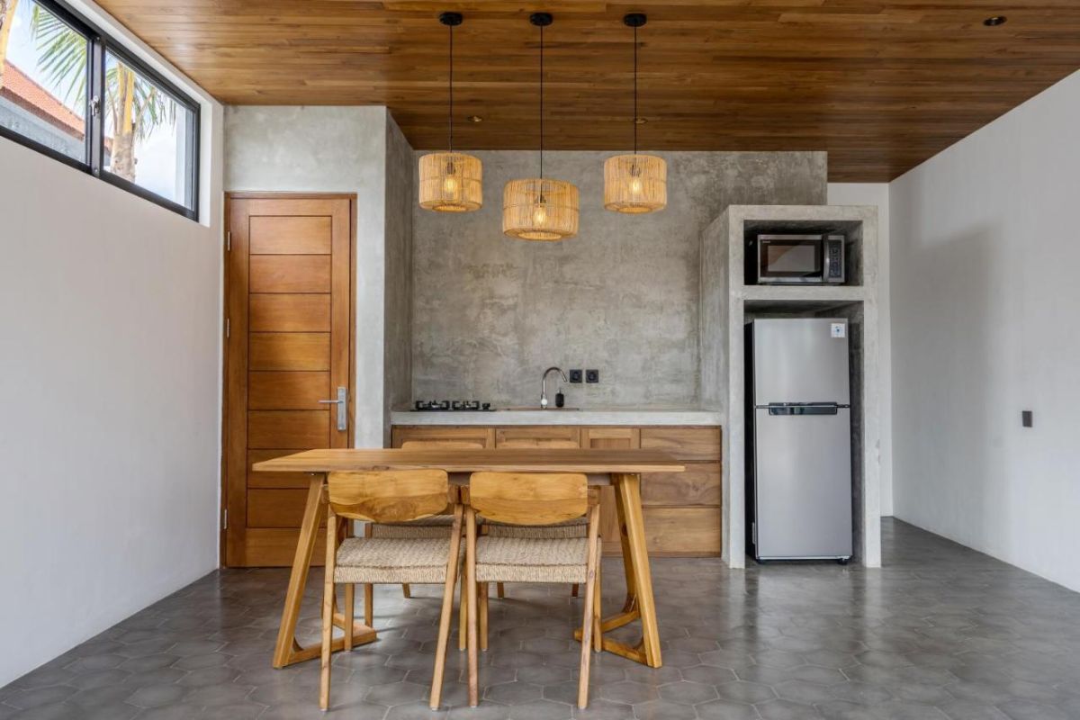 Serene modern bedroom with wooden bed, desk, and large windows overlooking lush green rice fields. - Bali Villas