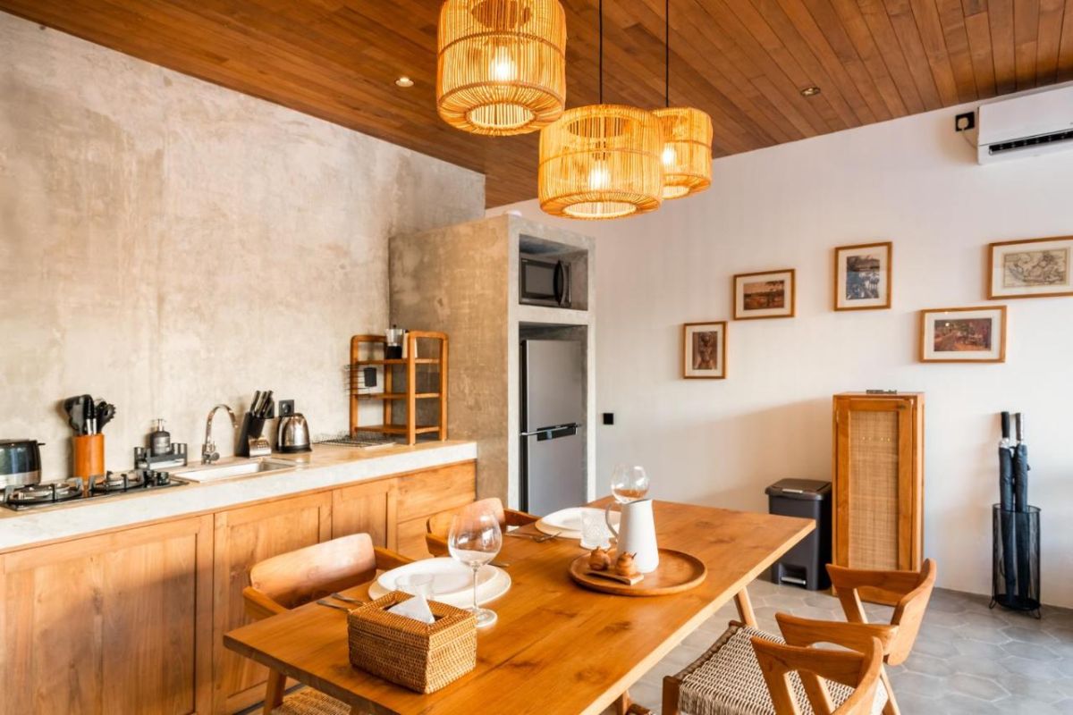 Serene modern bedroom with wooden bed, desk, and large windows overlooking lush green rice fields. - Bali Villas