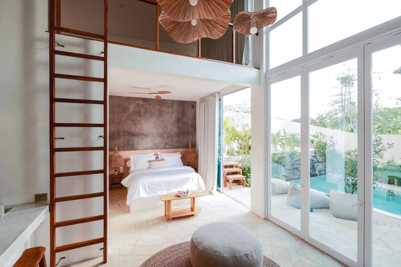 Serene bohemian bathroom with white bathtub, wooden vanity, rattan mirror, potted palm, and woven accents. - Bali Villas