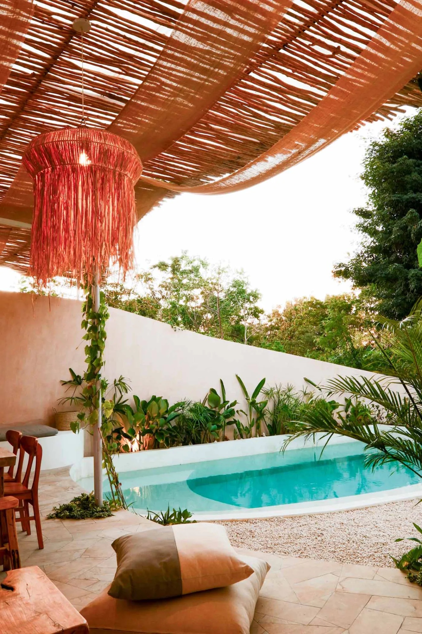 Serene bohemian bathroom with white bathtub, wooden vanity, rattan mirror, potted palm, and woven accents. - Bali Villas