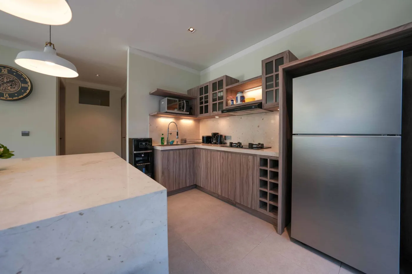 White freestanding bathtub filled with water and floating red rose petals in a modern spa-like bathroom. - Bali Villas
