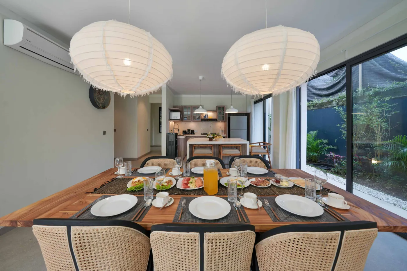 White freestanding bathtub filled with water and floating red rose petals in a modern spa-like bathroom. - Bali Villas