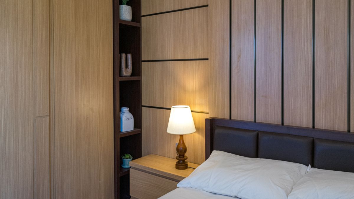 Serene Bali villa poolside patio with wooden dining set under blue umbrella, surrounded by tropical plants and traditional architecture. - Bali Villas