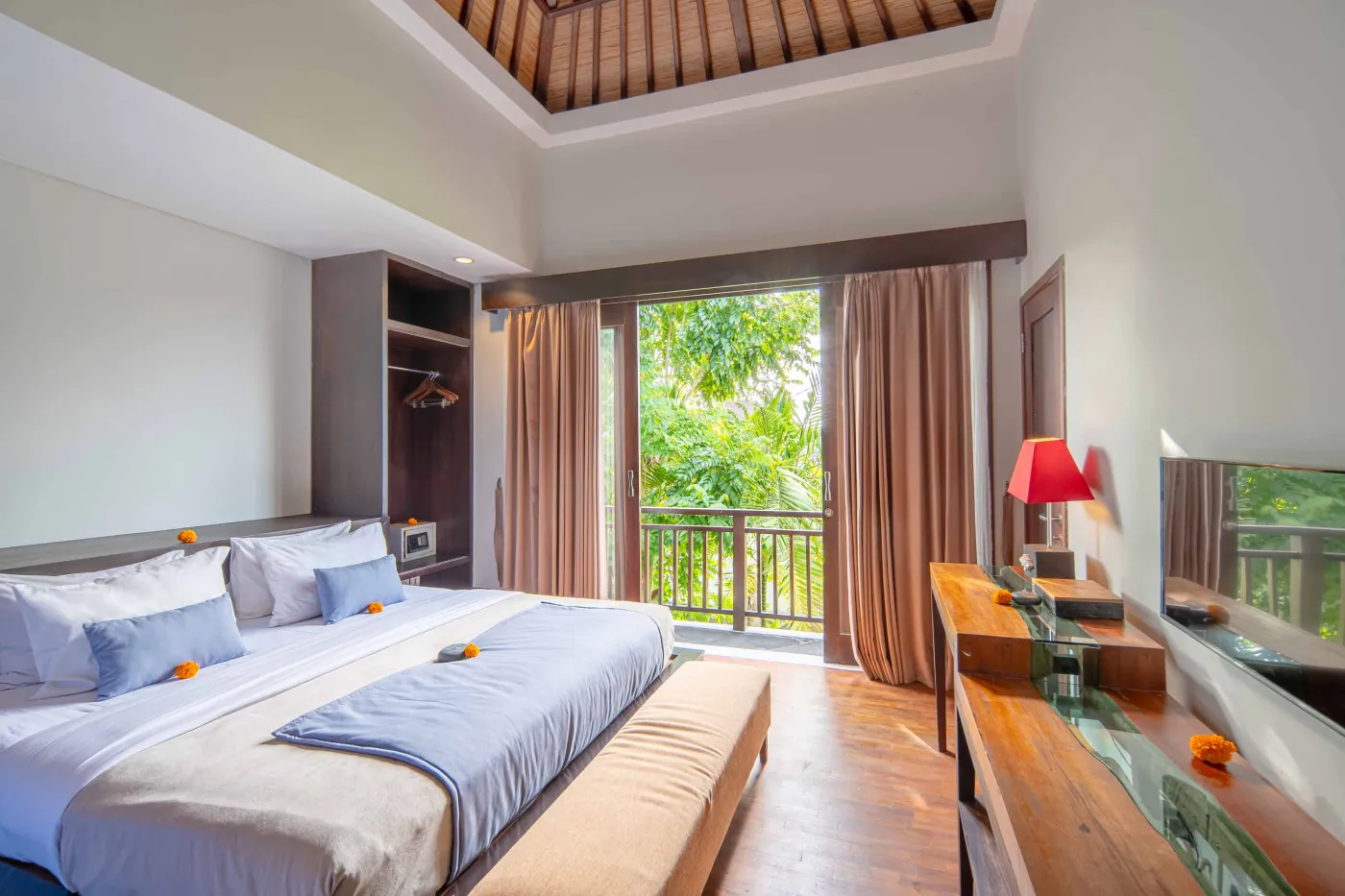 Luxury Bali villa bedroom with king bed, private infinity pool beyond sliding doors, wooden accents, and Netflix on TV. - Bali Villas