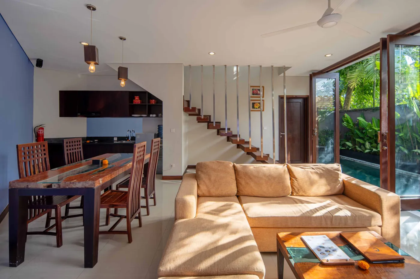 Luxury Bali villa bedroom with king bed, private infinity pool beyond sliding doors, wooden accents, and Netflix on TV. - Bali Villas