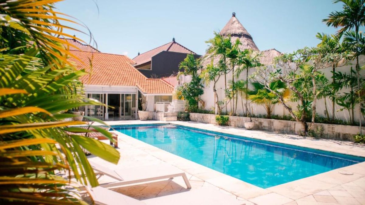 Bright tropical kitchen with fruit platter, stainless steel fridge, sink, and counter cabinets in a seaside villa. - Bali Villas