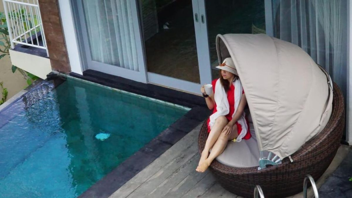 Modern outdoor shower with tropical plants, pebble flooring, and sleek black tile accents in a resort villa. - Bali Villas