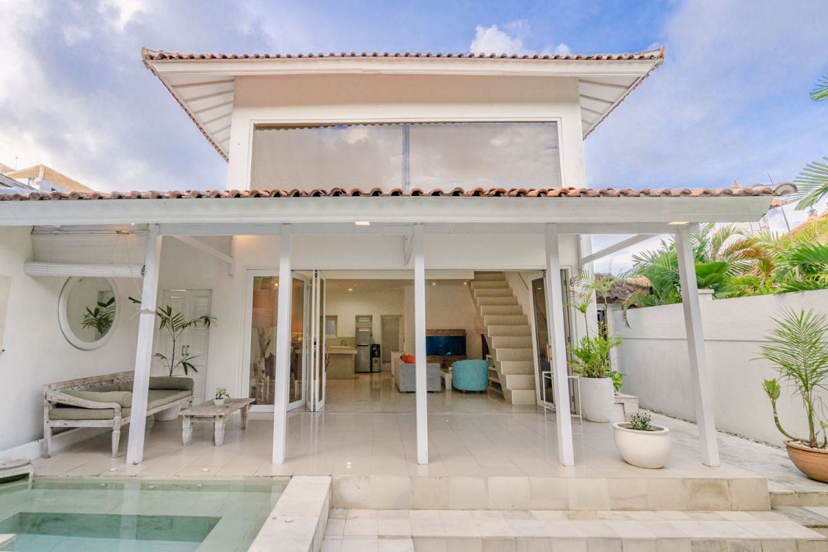 Modern white Bali-style villa with open patio, plunge pool, lounge seating, and tropical plants. - Bali Villas