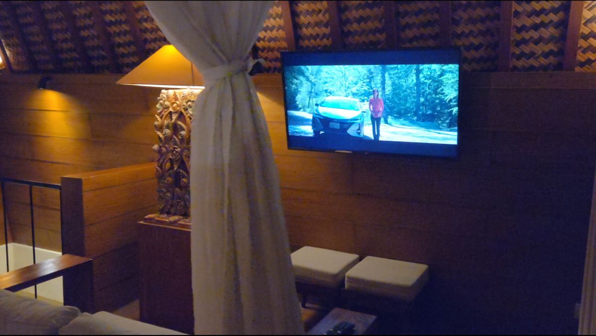 Modern outdoor shower with tropical plants, pebble flooring, and sleek black tile accents in a resort villa. - Bali Villas