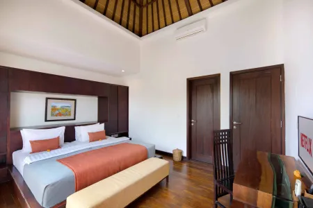 Luxurious Balinese villa bedroom with king bed, thatched ceiling, wooden accents, and tropical decor.