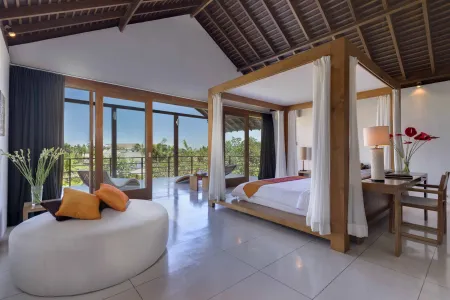 Luxurious tropical villa bedroom with four-poster bed, ocean-view balcony doors, and vibrant flower accents.