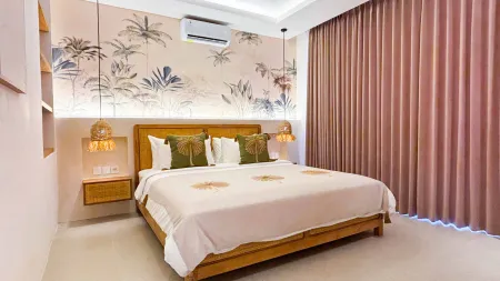 Cozy tropical bedroom with wooden bed, palm leaf wallpaper, rattan pendant lights, and blush pink curtains.