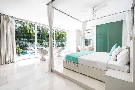 Luxurious tropical bedroom with white canopy bed, sliding glass doors to lush garden and infinity pool, and modern Balinese decor.
