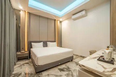 Modern hotel bedroom with king-sized bed, ambient LED ceiling lights, wooden accents, and marble flooring.