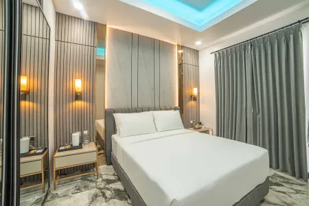 Modern luxury bedroom with white king bed, gray slatted headboard, mirrored walls, ambient LED lighting, and marble flooring.