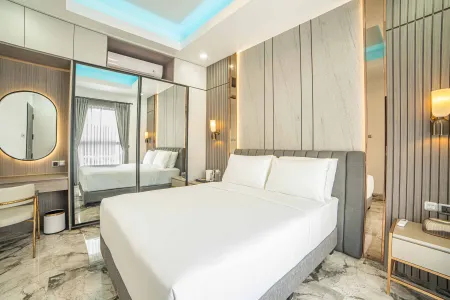 Modern luxury bedroom with king-sized bed, mirrored wardrobe, gray accent walls, and blue LED ceiling lights.