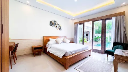 Elegant tropical bedroom with wooden bed, pool view through glass doors, and neutral decor.