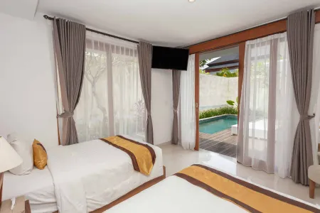 Spacious tropical bedroom with two king beds, sheer curtains, and sliding doors opening to a private infinity pool.