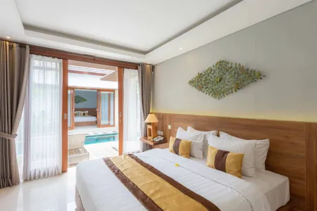 Luxurious Balinese villa bedroom with king bed, wooden accents, and private plunge pool view through open doors. - Bali Villas