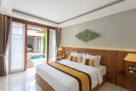 Luxurious Balinese villa bedroom with king bed, wooden accents, and open doors to private plunge pool.