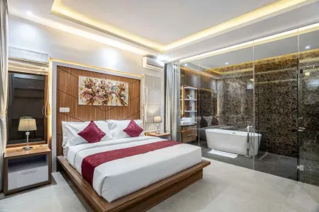 Luxurious modern bedroom with wooden king bed, abstract floral headboard, bedside lamps, and open-plan glass bathroom with freestanding bathtub.